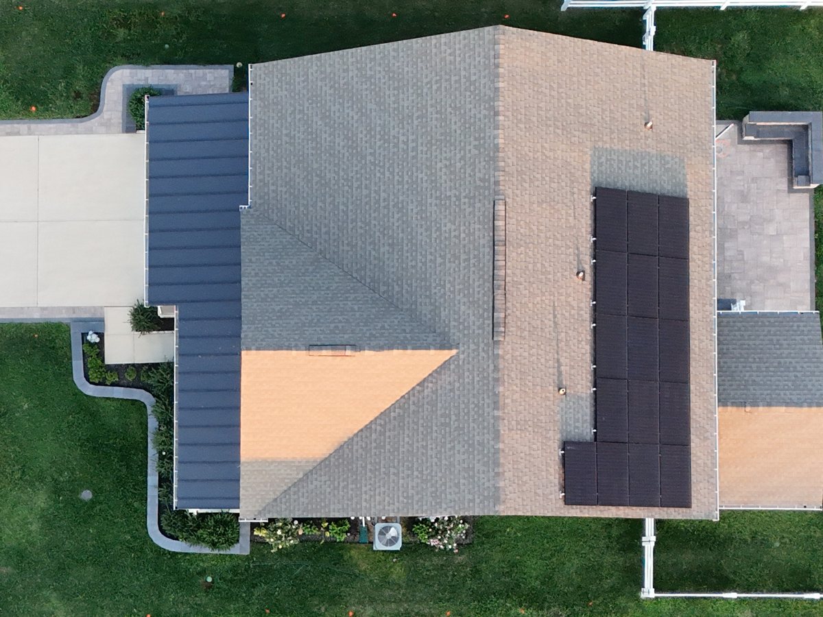 Straight-down view of a house roof with the lot and driveway around it