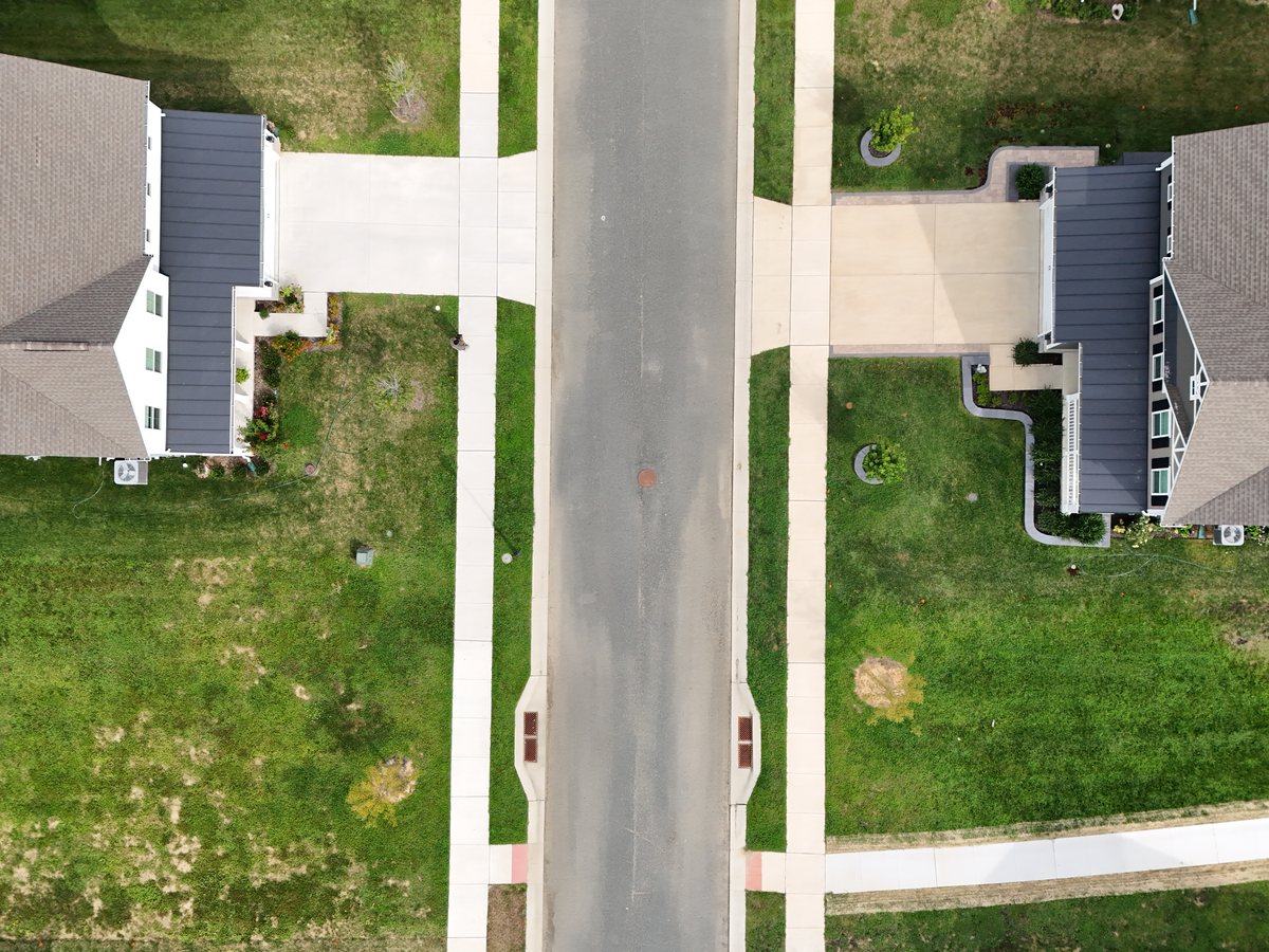 Straight-down view of a residential street running between two houses