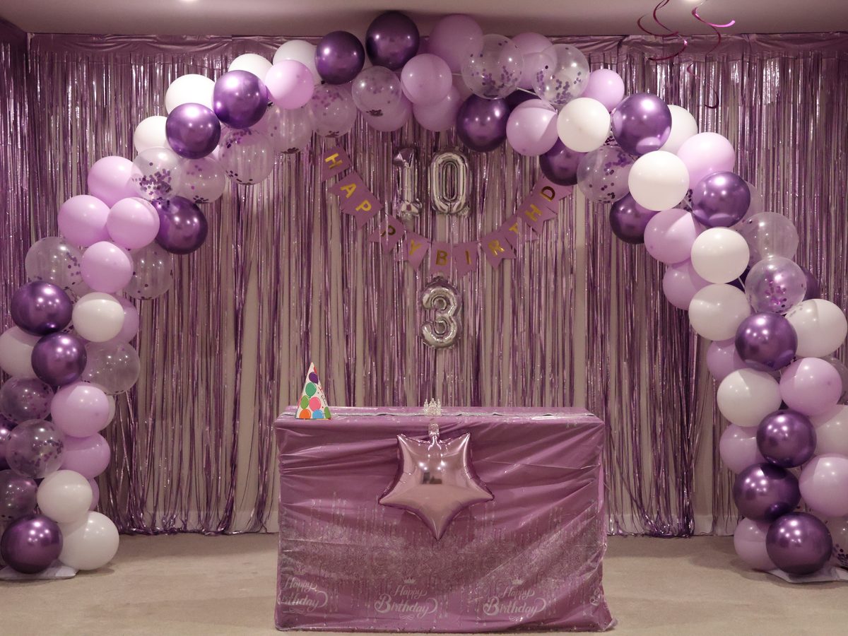 Balloon arch, banner and dressed table set up for a birthday party
